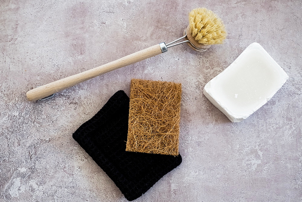 High angle close up of wooden washing up brush, soap and sponges