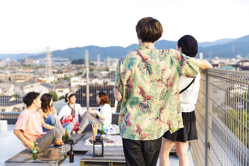 Group of young Japanese men and women on a rooftop in an urban setting, Fukuoka, Kyushu, Japan