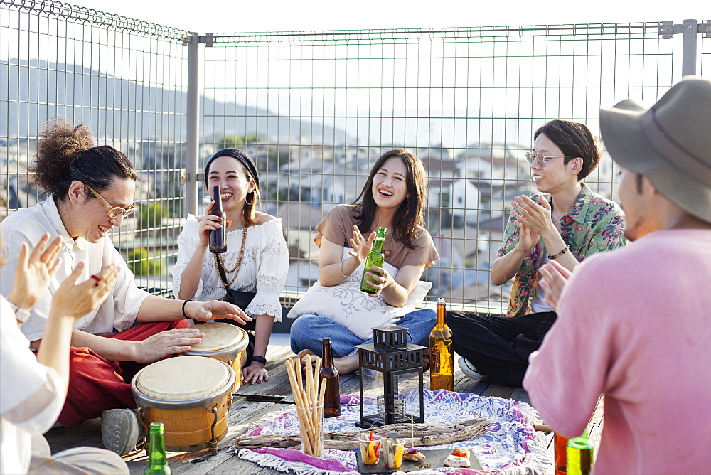 Group of young Japanese men and women standing on a rooftop in an urban setting, Fukuoka, Kyushu, Japan