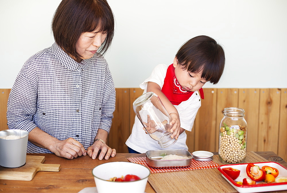 Japanese woman and boy standing in a farm shop, preparing food, Kyushu, Japan