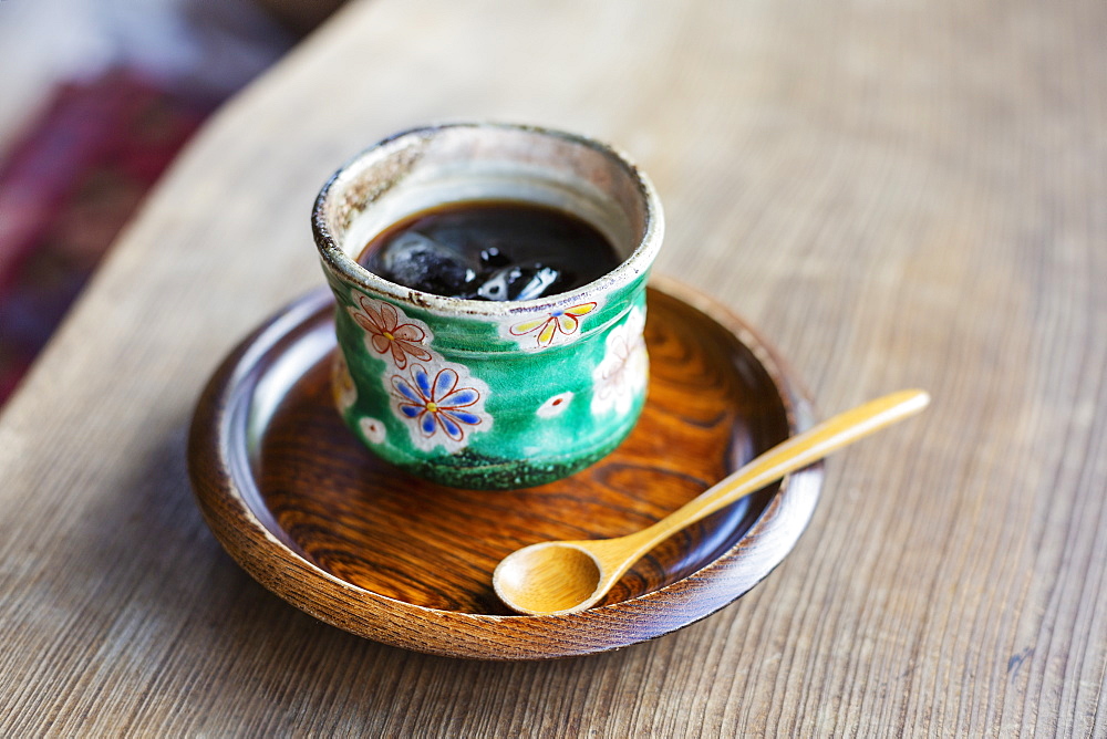 High angle close up of Japanese condiment in green bowl on wooden plate, Kyushu, Japan