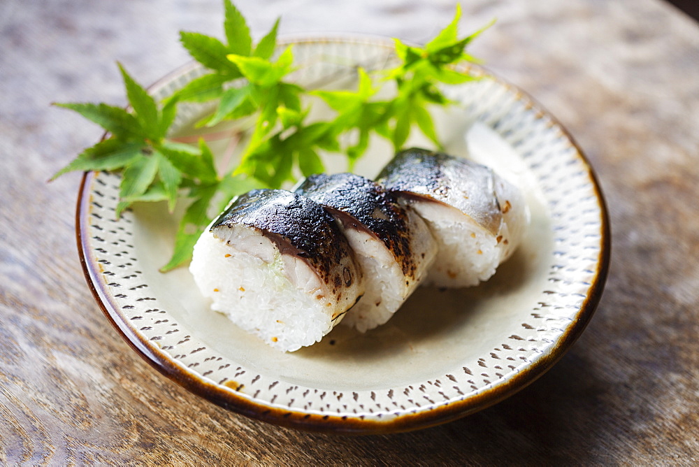 High angle close up of plate of Sushi and bowl of Soy Sauce on a table in Japanese restaurant, Kyushu, Japan