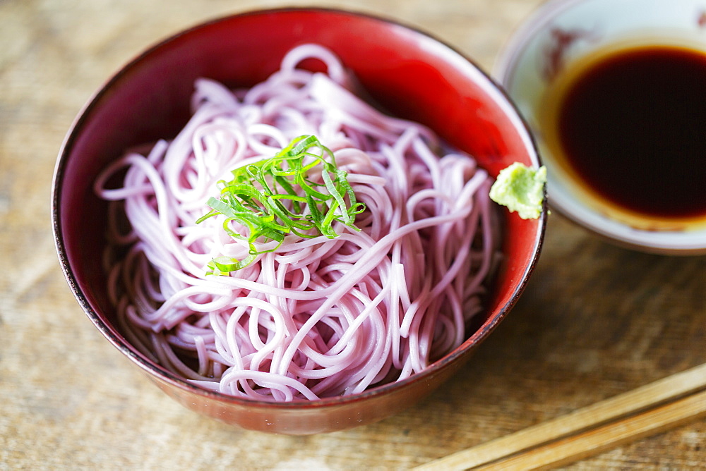 High angle close up of bowl of pink noodles on a table in Japanese restaurant, Kyushu, Japan