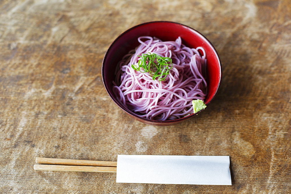 High angle close up of bowl of pink noodles on a table in Japanese restaurant, Kyushu, Japan