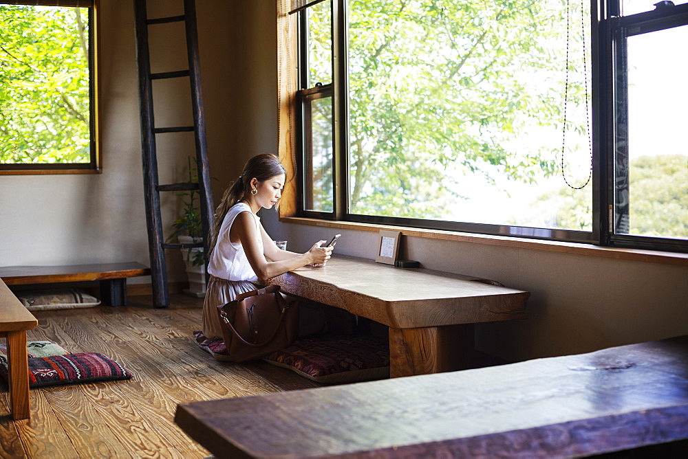 Japanese woman sitting at a table in a Japanese restaurant, Kyushu, Japan