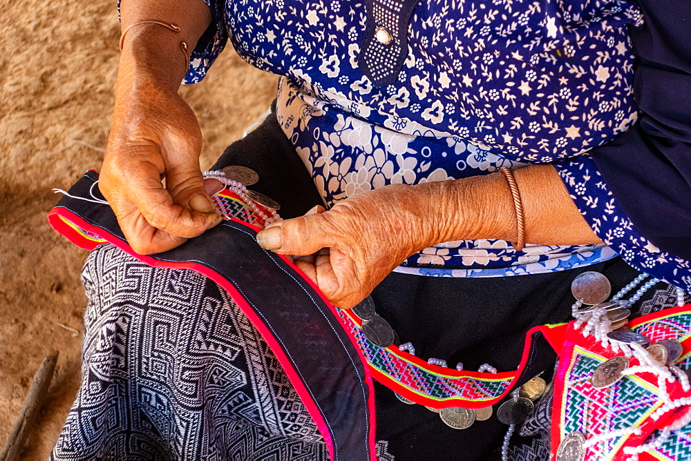 Woman seated stitching, making traditional garments, Vang Vieng, Laos, Laos