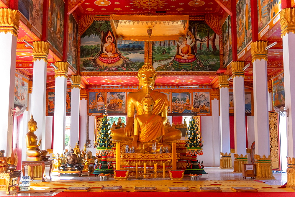 Wat Si Saket, a large golden Buddha statue and altar with offerings and wall murals, Vientiane, Laos, Laos