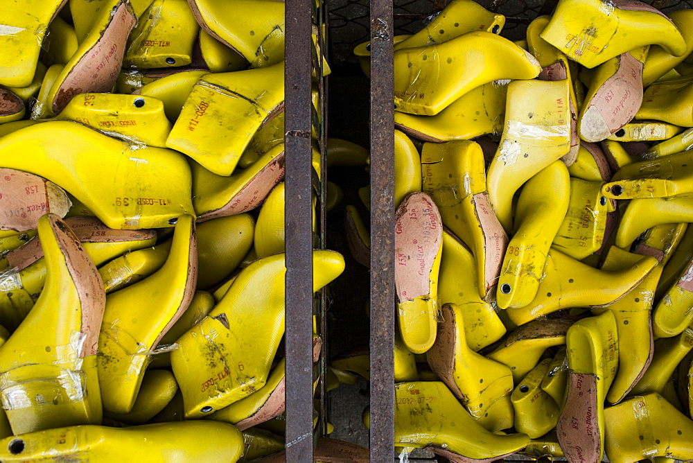 High angle close up of bins of yellow shoe molds in a factory, Vietnam