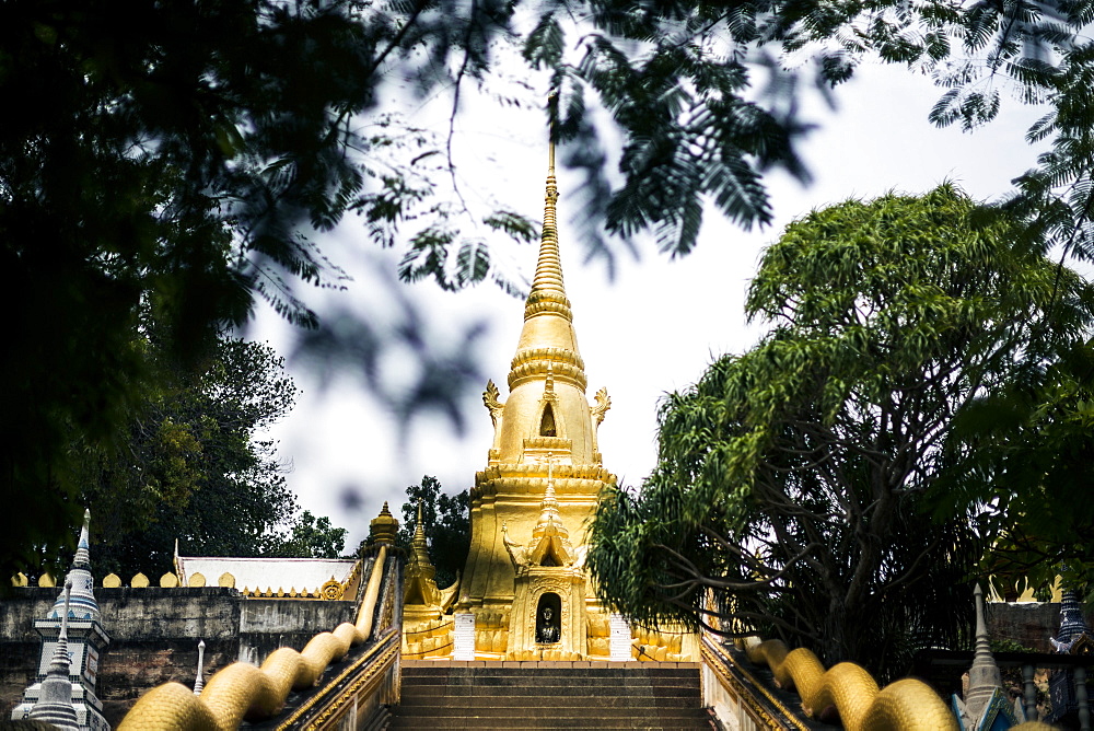 Exterior view of small local temple with golden stupa, Thailand