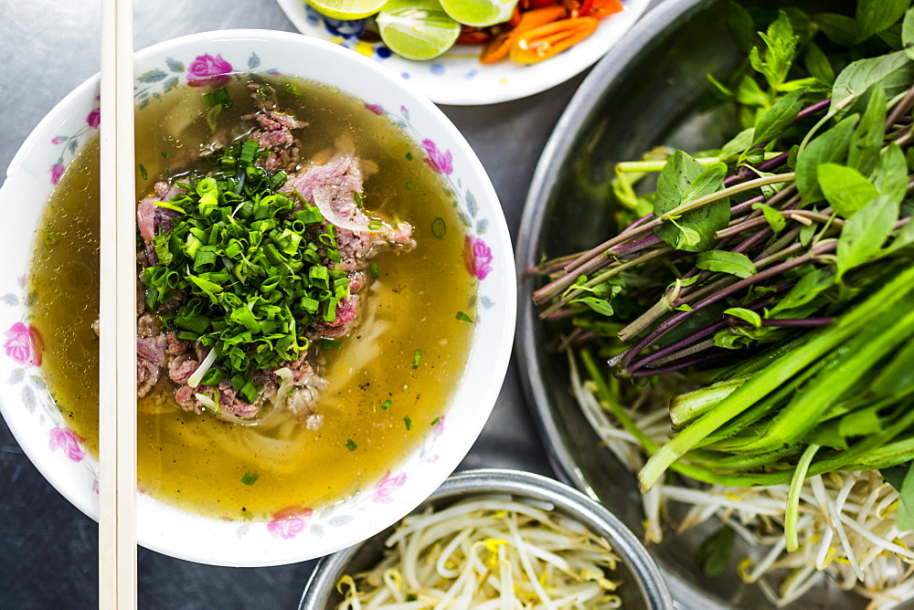 High angle close up of Beef pho, bowl of soup with beef, noodles and vegetables, Vietnam