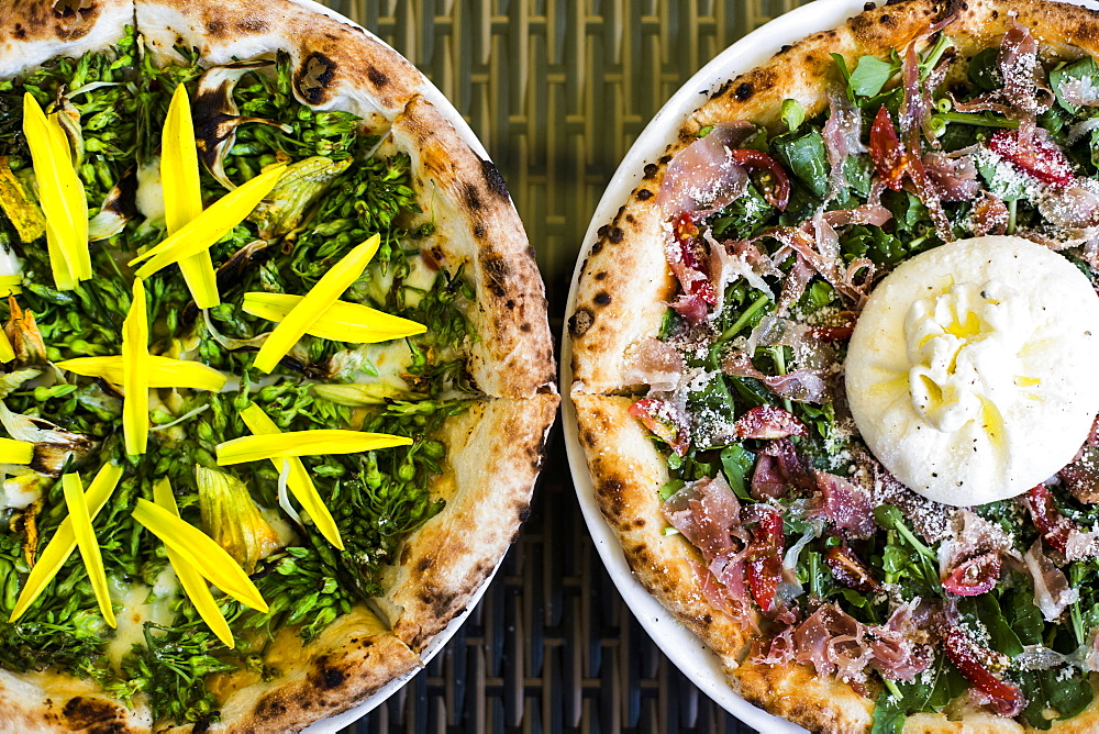 High angle close up of a Burrata Prosciutto pizza with arugala, Vietnam