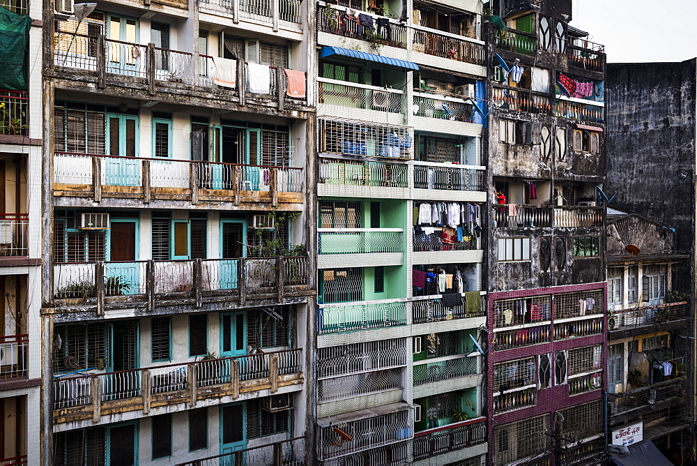 Facade of rows of run down apartment houses with washing hanging on balconies, Myanmar