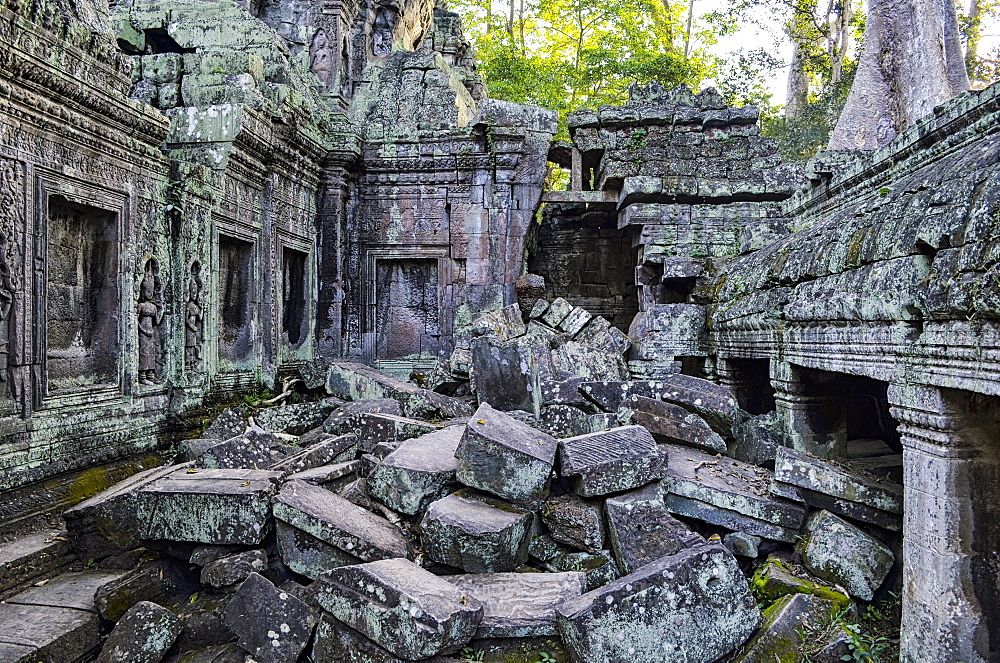 Ankor Wat, a 12th century historic Khmer temple and UNESCO world heritage site. Arches and carved stone blocks, fallen masonry and structures being overgrown by the jungle, Angkor Wat, Cambodia