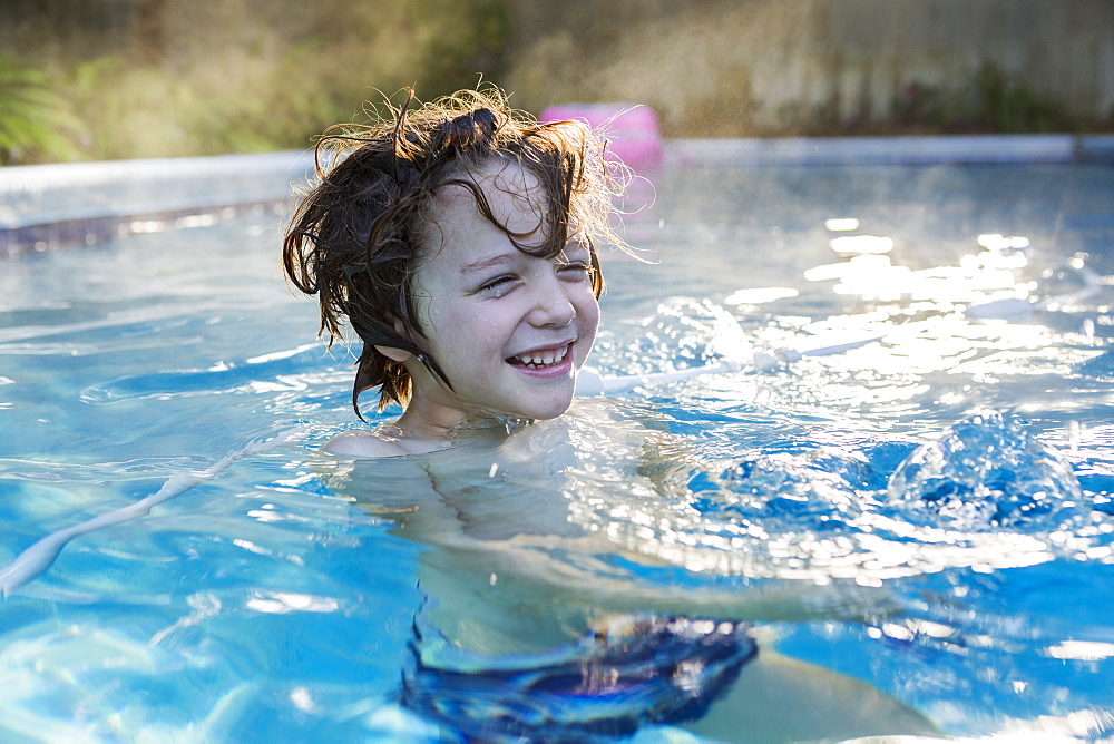 A six year old boy swimming in a warm pool, St Simon's Island, Georgia, United States