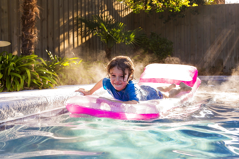 A young boy playing in pool at sunrise, St Simon's Island, Georgia, United States