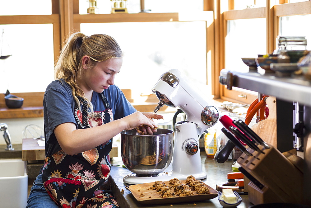 A teenage girl using mixer in the kitchen, United States