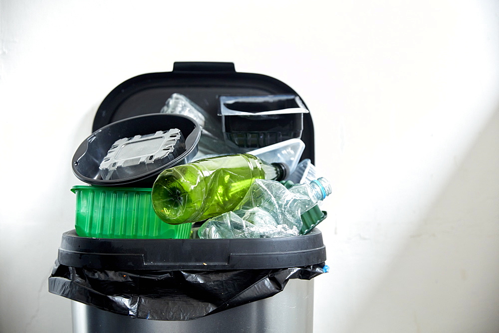 Used plastic containers filling up kitchen dustbin, Bristol, United Kingdom