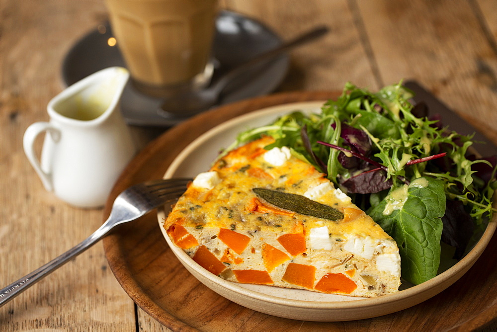 High angle close up of frittata with a with baby leaf salad in a cafe