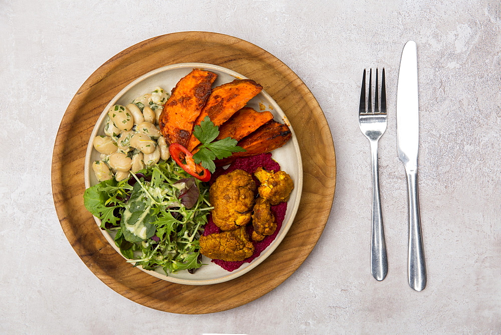 High angle close up of cutlery and bowl of mixed vegetables in a cafe