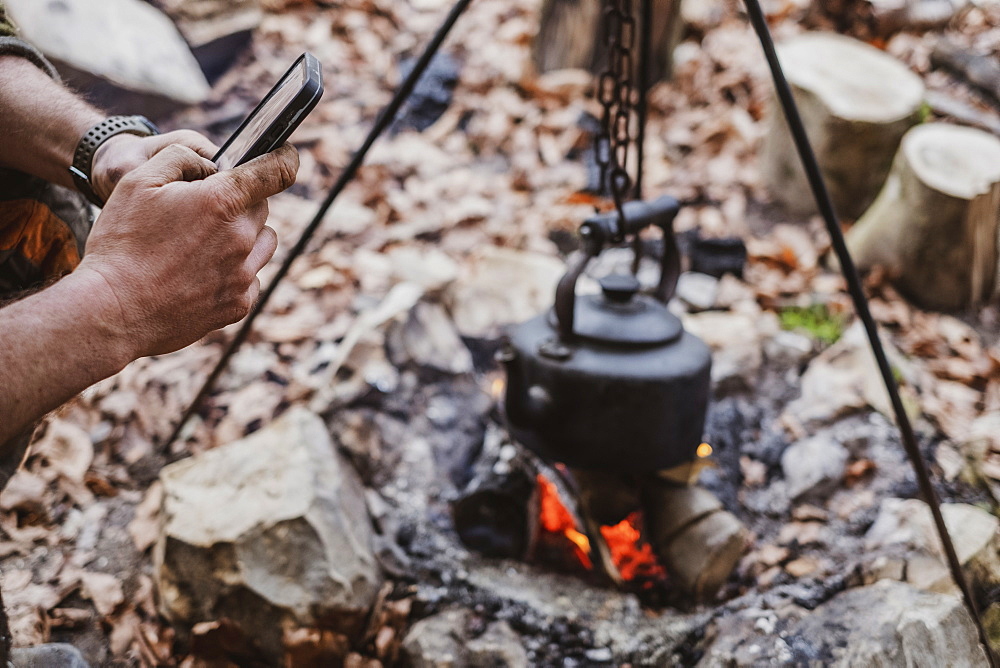 High angle close up of kettle over camp fire in a forest, Devon, United Kingdom