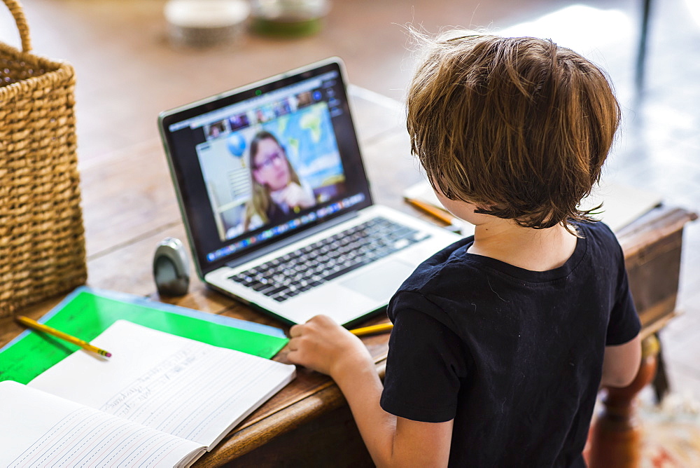 6 year old boy having a remote schooling session with his teacher