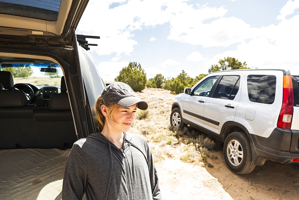 14 year old girl resting on SUV, Galisteo Basin, New Mexico, United States of America