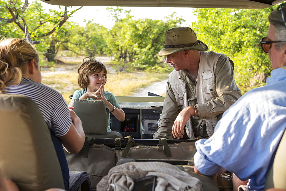 A family of visitors in a safari vehicle with a guide, Moremi Game Reserve, Botswana