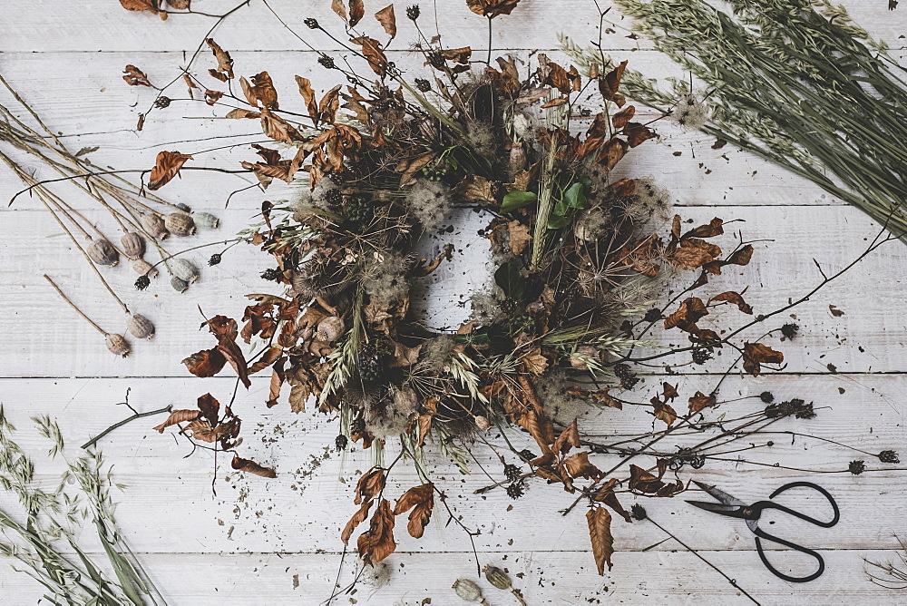 A wreath made from twigs and dried leaves, teasels and seedheads,