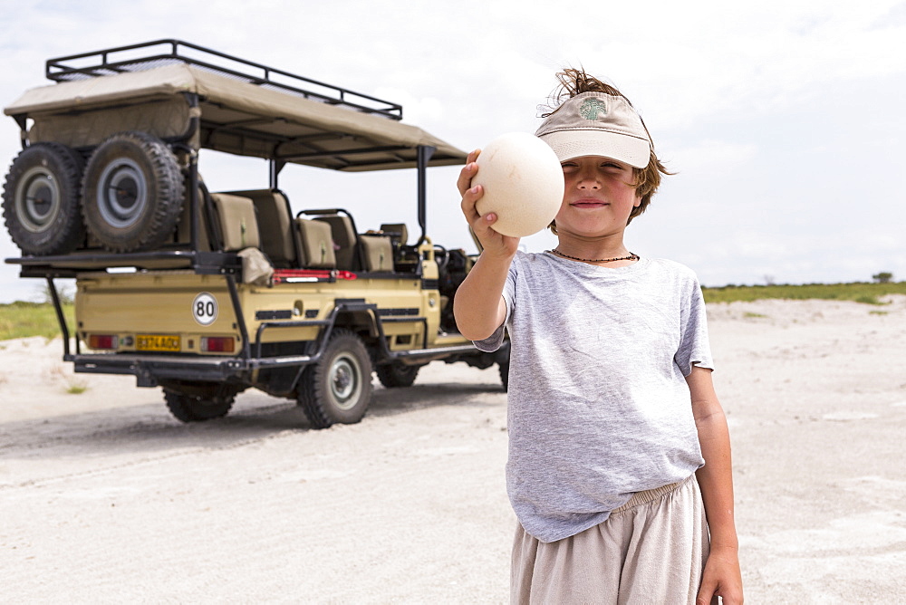 Boy holding up a large ostrich egg