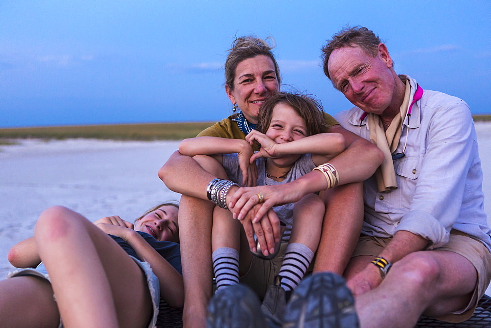 smiling family on top of safari vehicle, Nxai Pan, Botswana