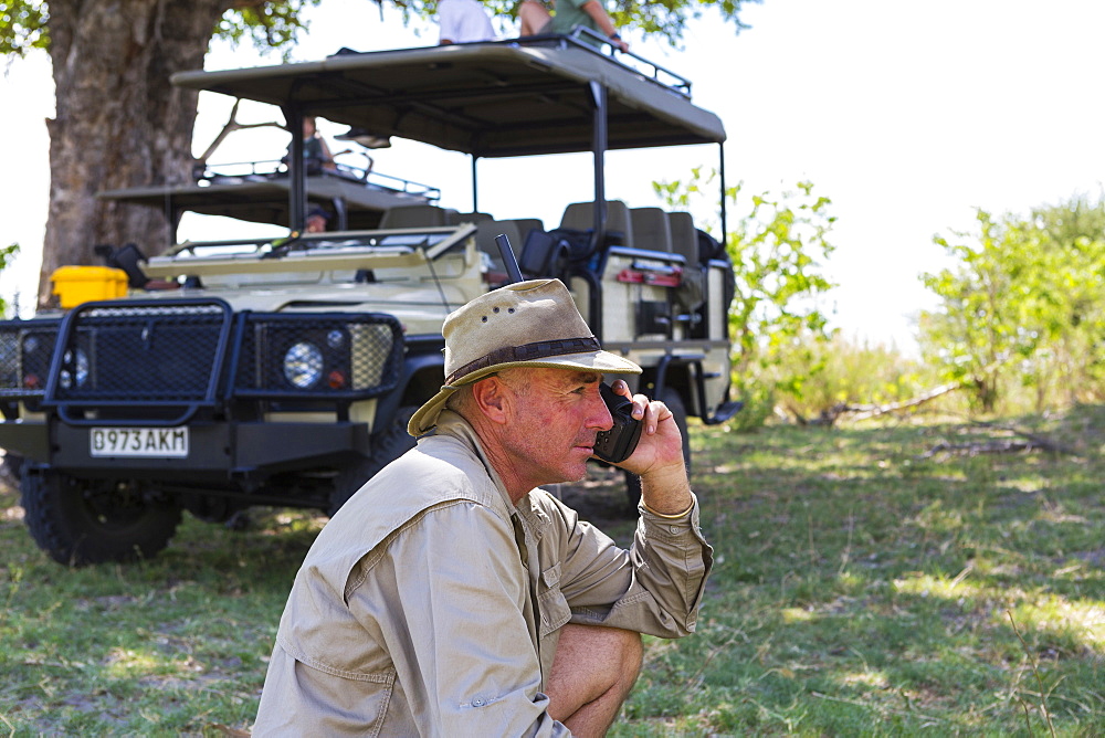 A guide in a bush hat on the radio at Moremi Game Reserve, Botswana