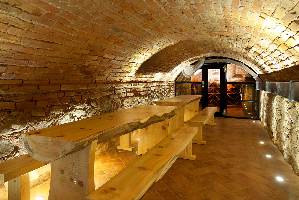 Climate controlled wine cellar, with a domed brick ceiling and walls, stacked benches, Estonia