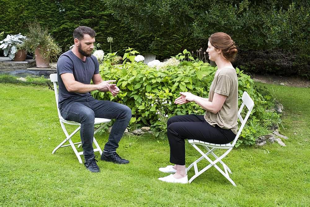 Man and female therapist engaged in alternative therapy session in a garden