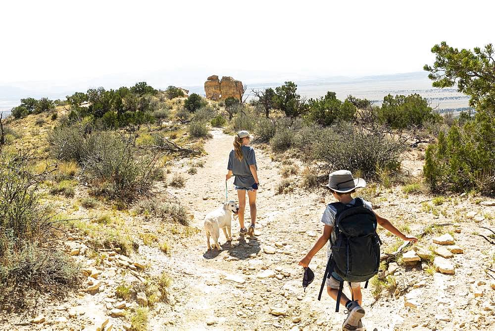 children hiking on Chimney Rock trail, through a protected canyon landscape, New Mexico, United States of America