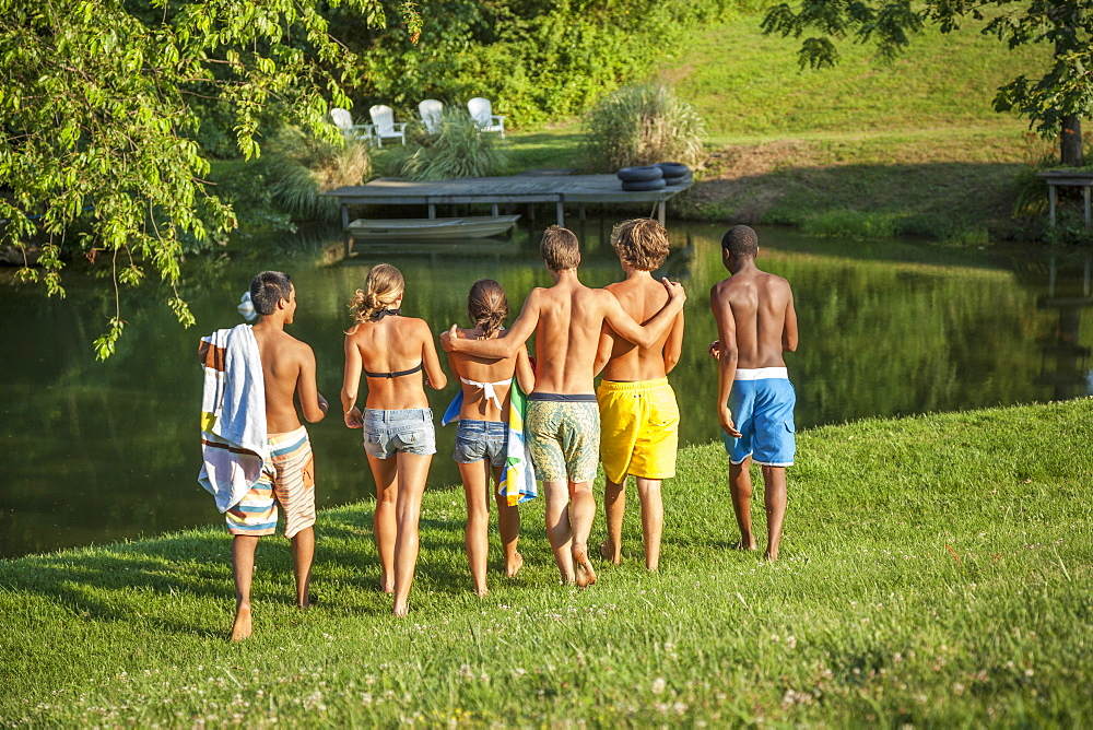 A large group of boys and girls, teenagers, running across a field, Maryland, USA