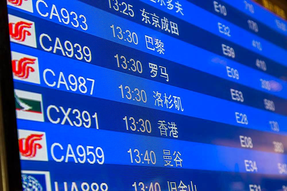 Close-up of departure board in airport terminal, Beijing, China, China