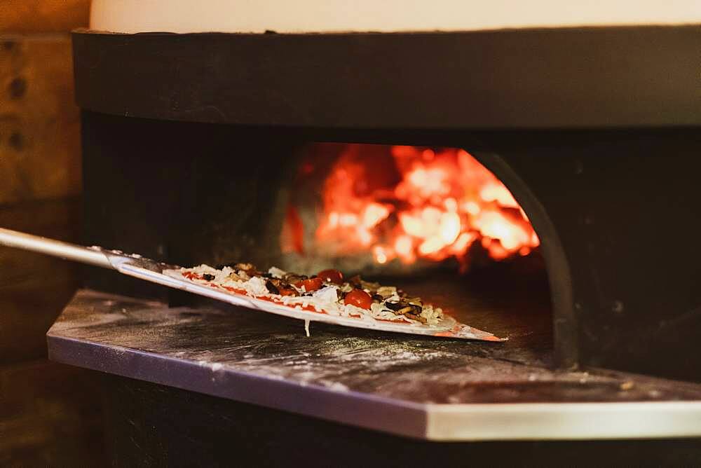 Close up of pizza in a wood-fired oven in a restaurant