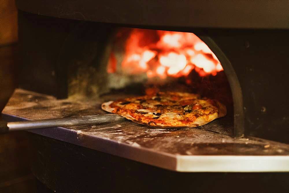 Close up of pizza in a wood-fired oven in a restaurant