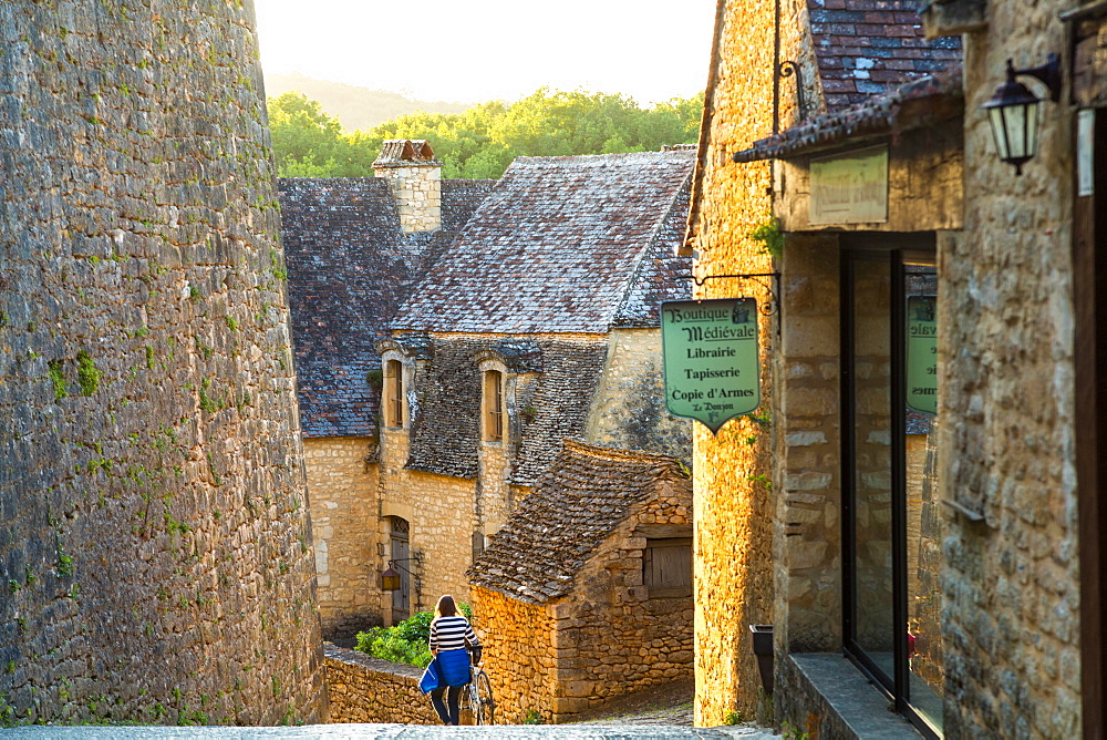 Young woman cyclist, Beynac-et-Cazenac, Beynac, Dordogne, France