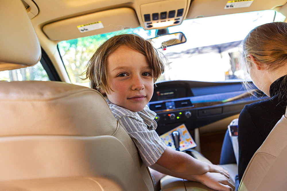 Young boy looking at camera in parked car