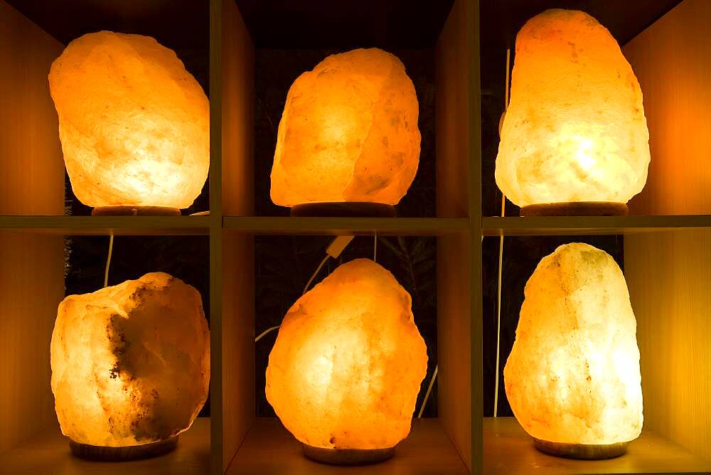 Lit up salt crystal lamps on shelves