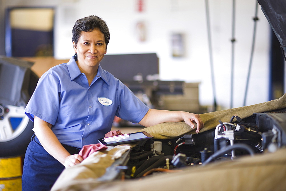 Portrait of female hispanic mechanic in auto repair shop