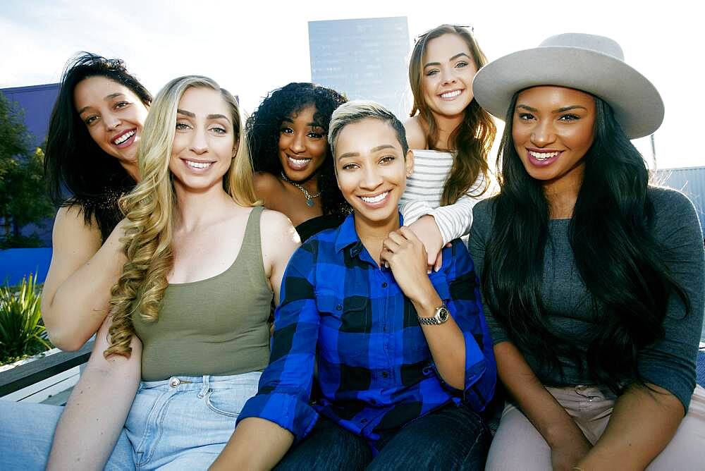 A group of young women partying on a city rooftop at dusk