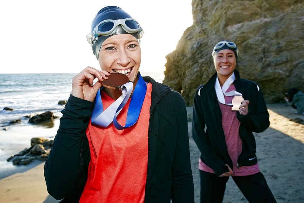 Two sisters, triathletes in training wearing their large medals, winners.