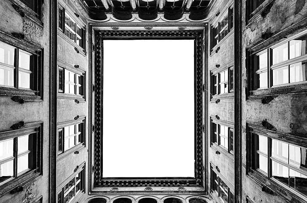 Architecture, the central courtyard of a tall historic building, windows and cornicing.