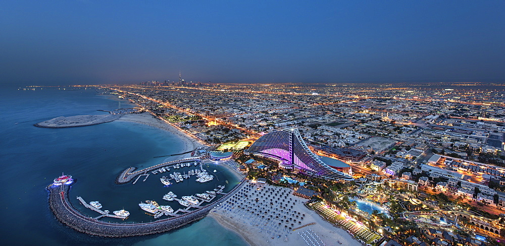 Cityscape of Dubai, United Arab Emirates at dusk, with coastline of Persian Gulf and marina in the foreground, Dubai, United Arab Emirates