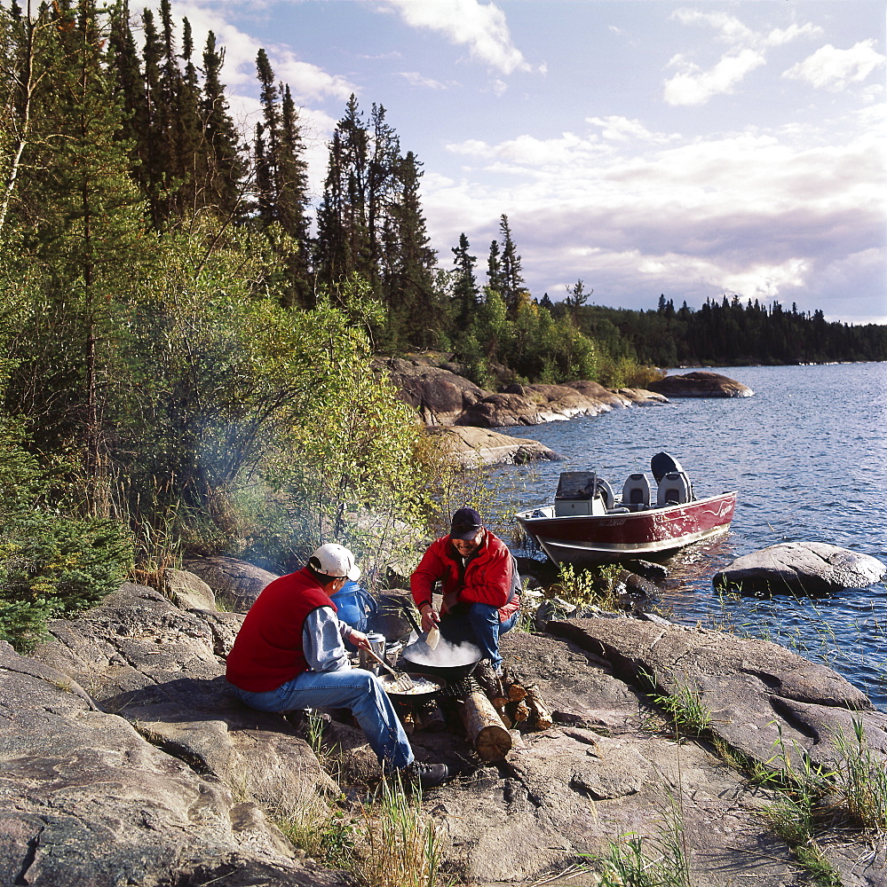 Two men beside a fire on the lake shore