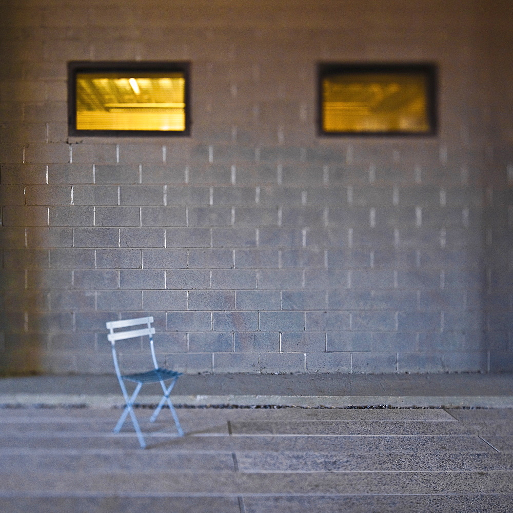 Folding chair in front of concrete block wall