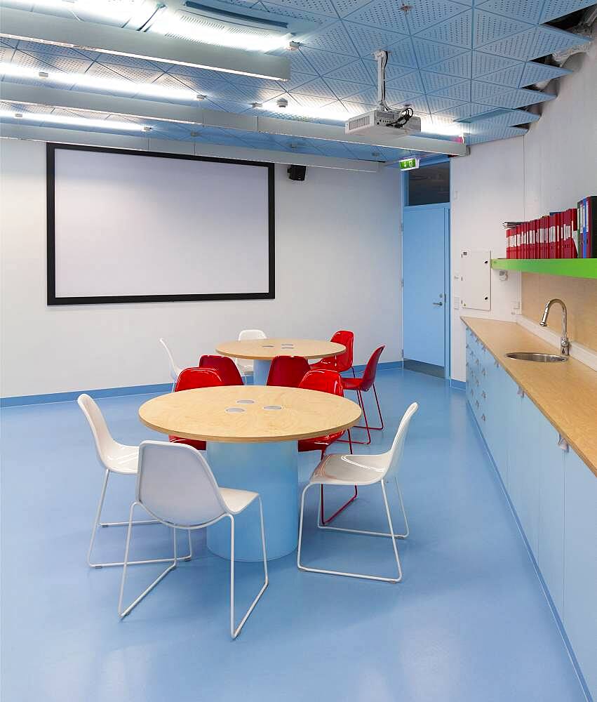 Classroom with white board, round tables and counter and sink