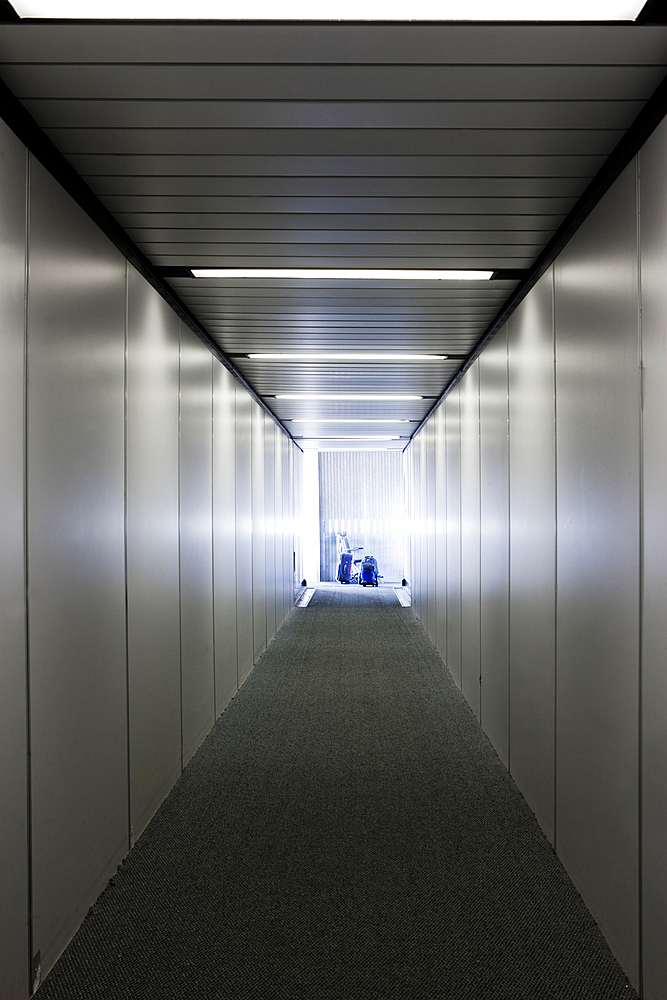 An empty narrow tunnel or corridor, a passenger airbridge.